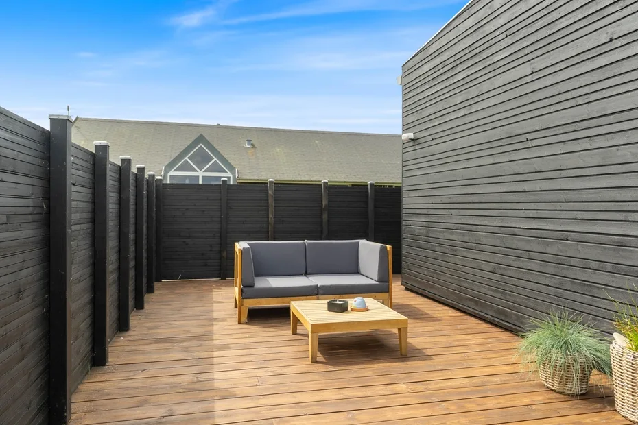 Una terraza exterior con una zona de estar y una mesa baja.