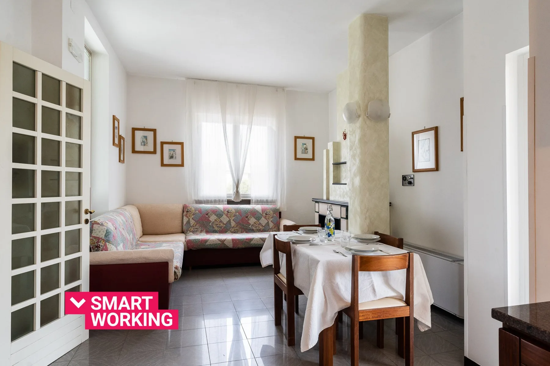 Una sala de estar y comedor con asientos, una mesa y una ventana luminosa.