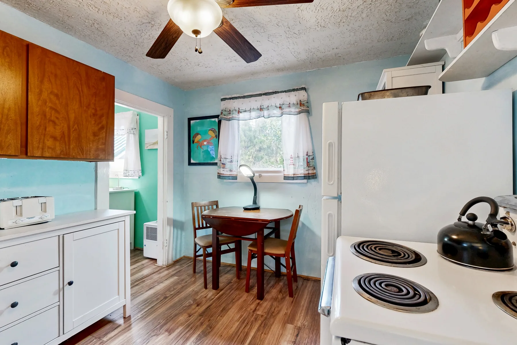 A compact kitchen and dining area with a table beside the window.