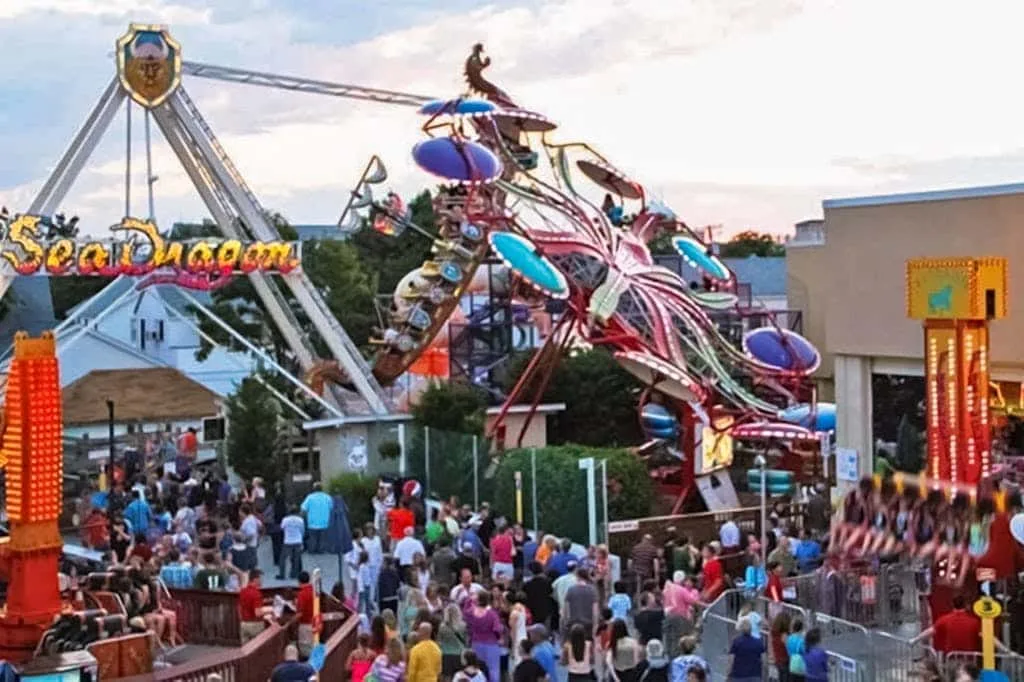 Una atracción de feria se eleva sobre un recinto al aire libre lleno de gente.