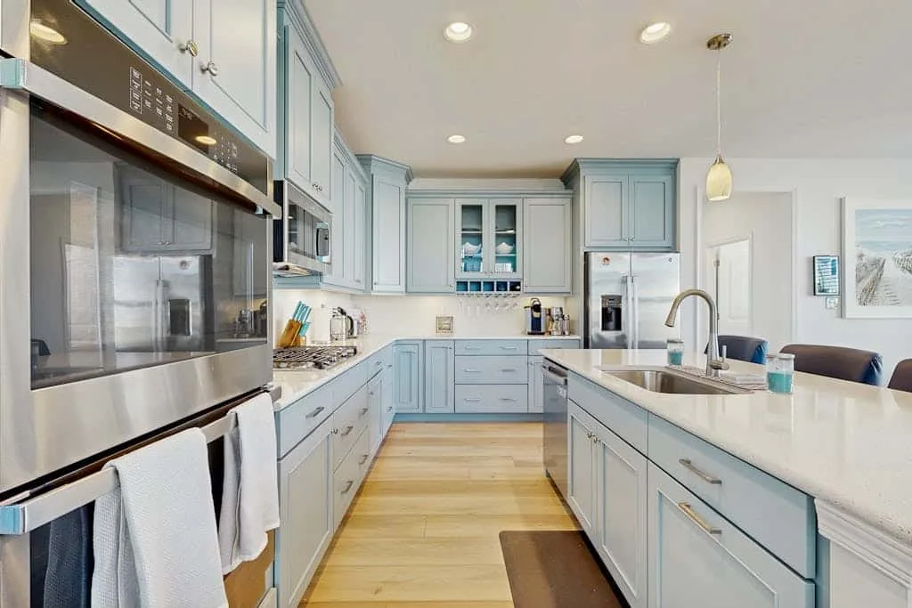 Una cocina luminosa con gabinetes azul claro y una gran isla central.