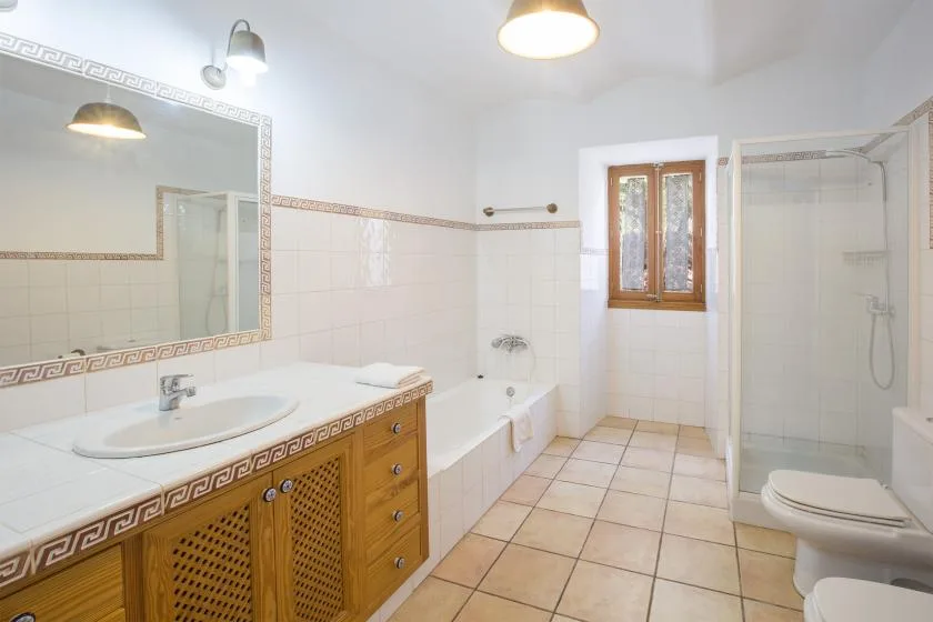 A tiled bathroom with a sink vanity, bathtub, and shower.