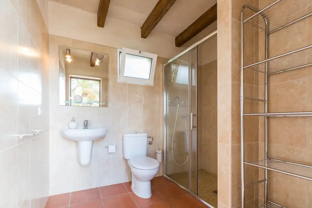 A bathroom with a sink, toilet, and glass shower enclosure.