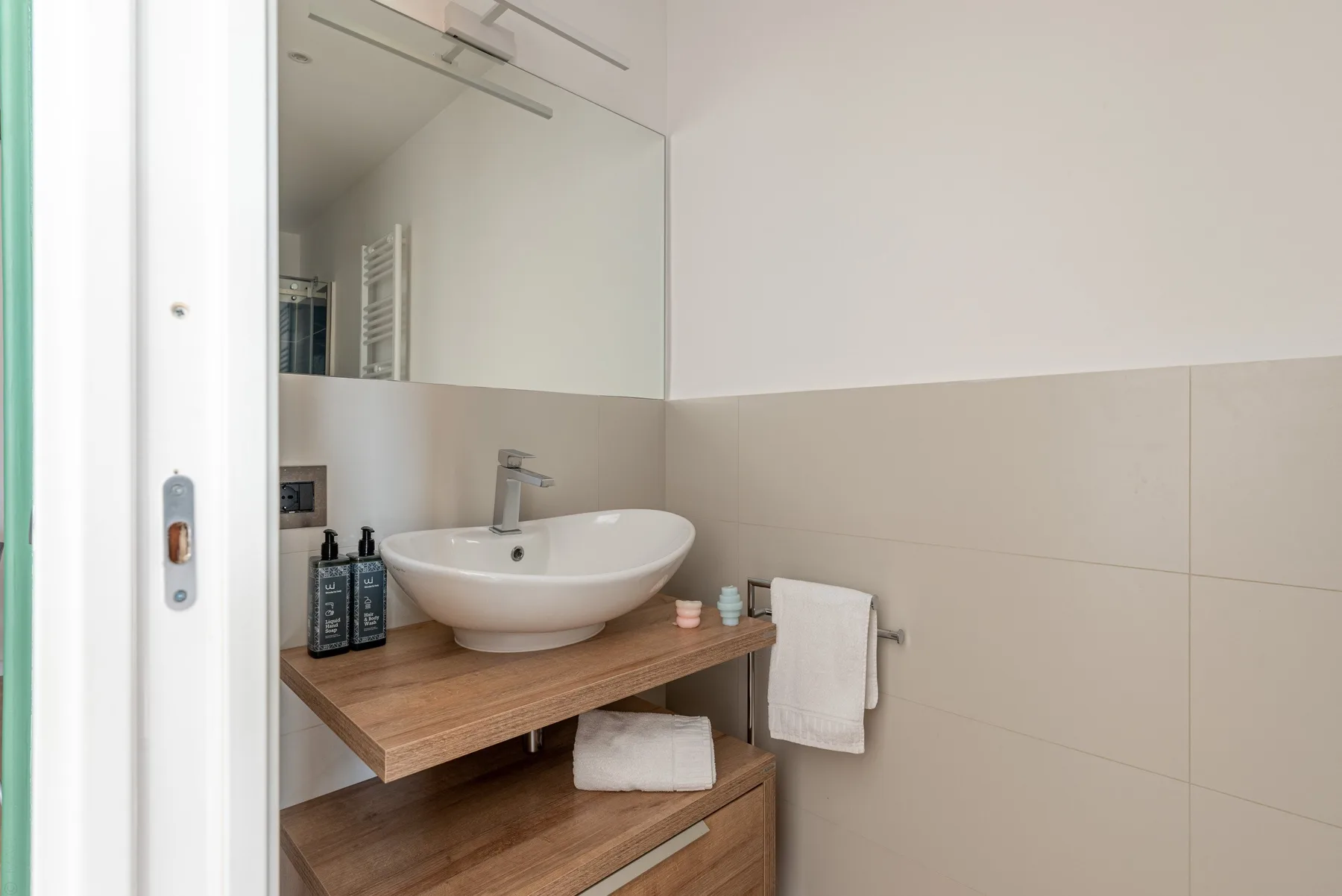 A bathroom vanity with a vessel sink, mirror, and towel.