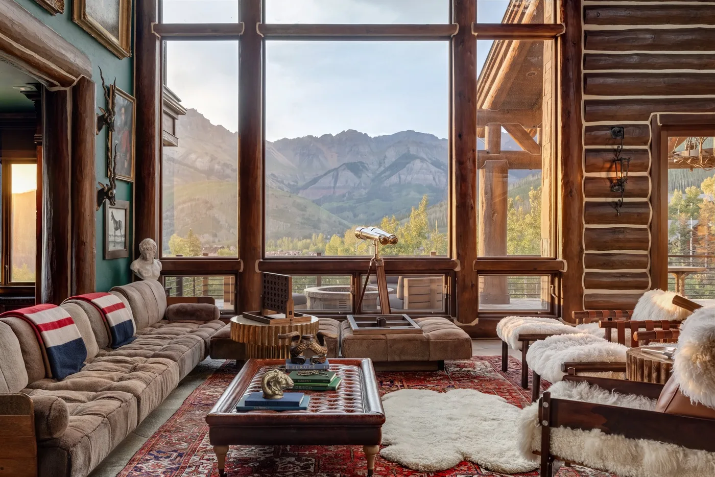 A spacious living room with large windows overlooking a mountain landscape.