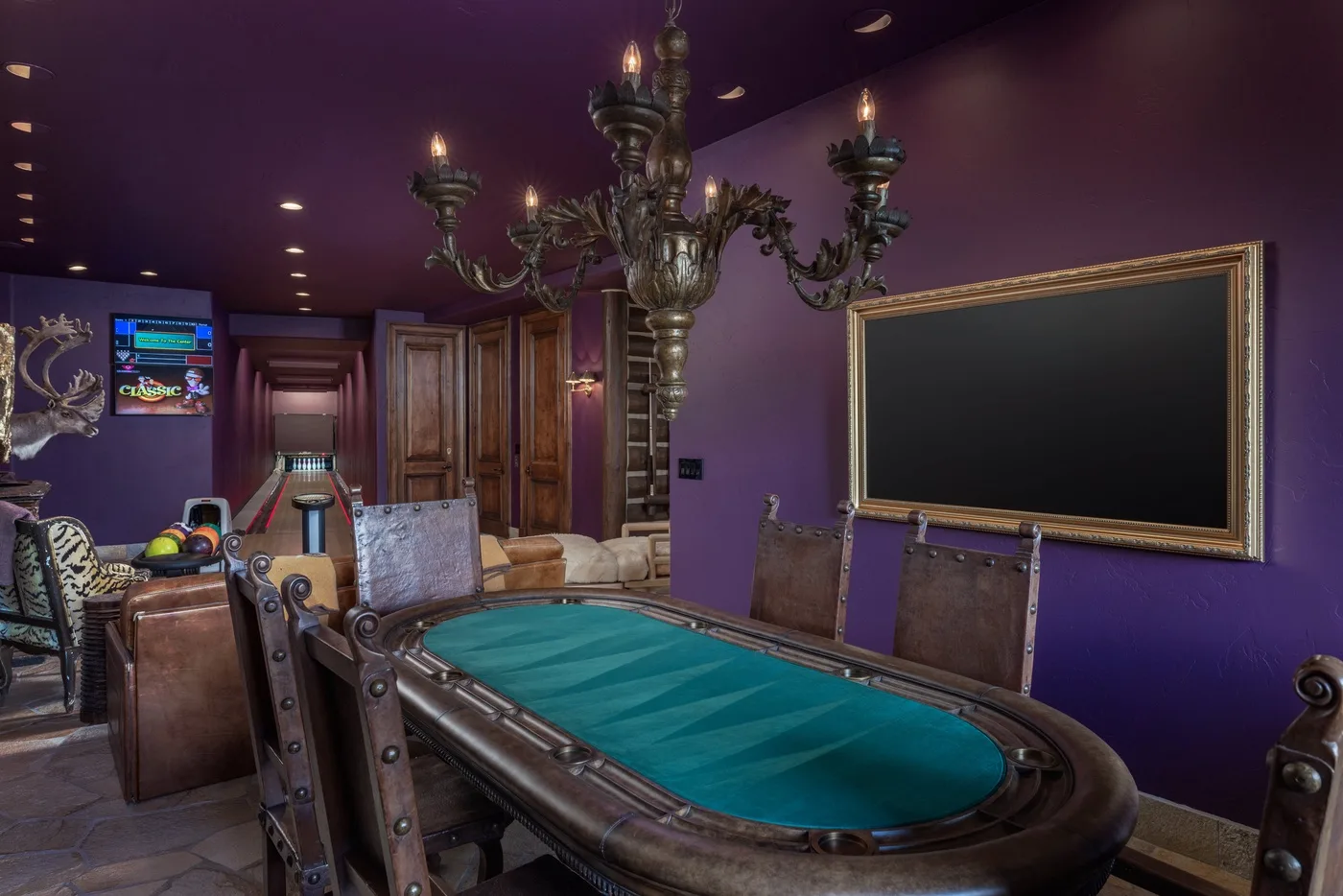A billiards room with a green-felt pool table and a large framed board.