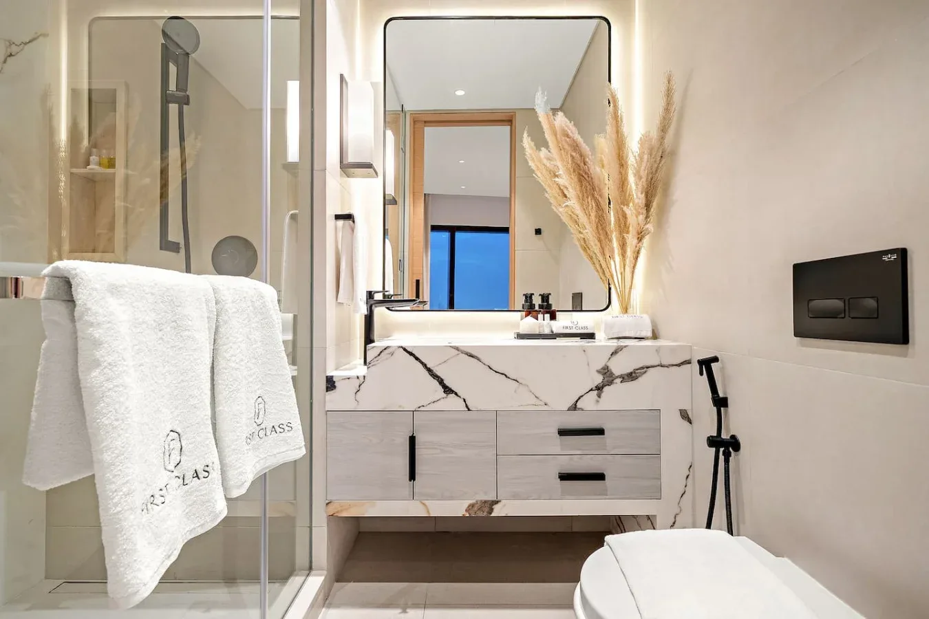 Un baño moderno con ducha de vidrio y un lavabo bajo un espejo.