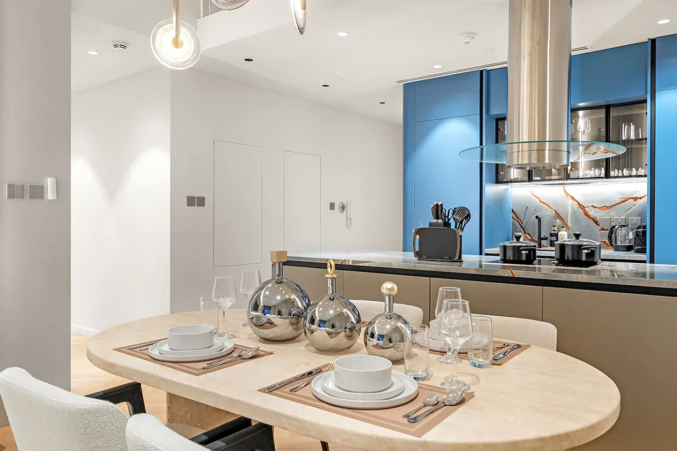 Comedor con la mesa puesta junto a una cocina moderna.