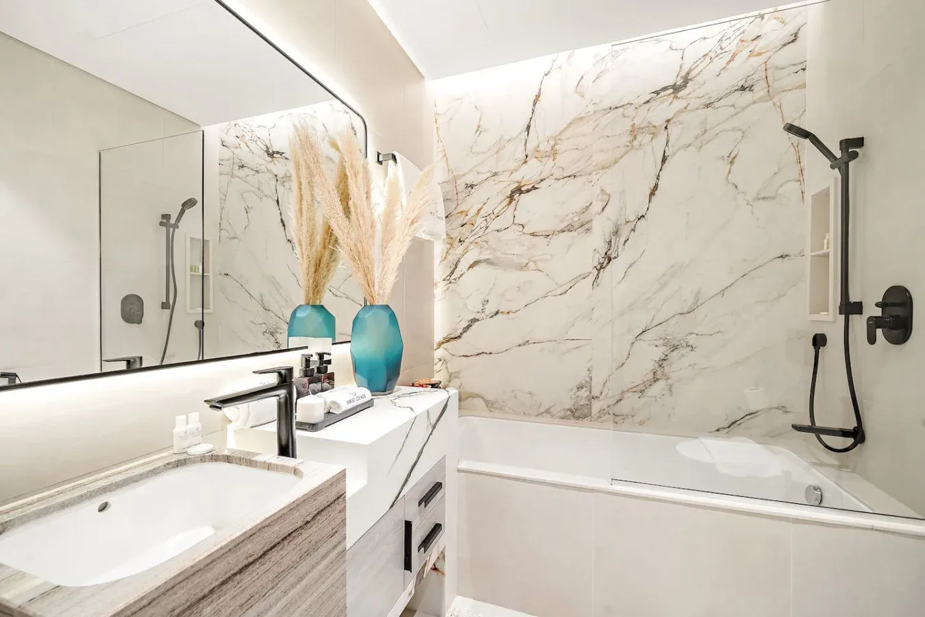 Un baño luminoso con bañera, ducha y lavabo.