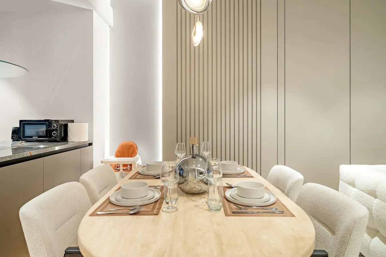 Comedor con la mesa puesta y asientos tapizados.