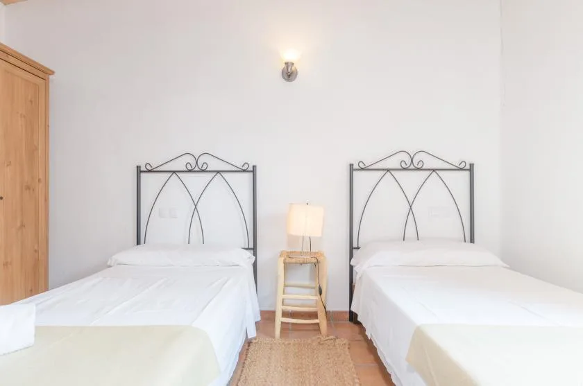 A bedroom with two beds and a small table between them.