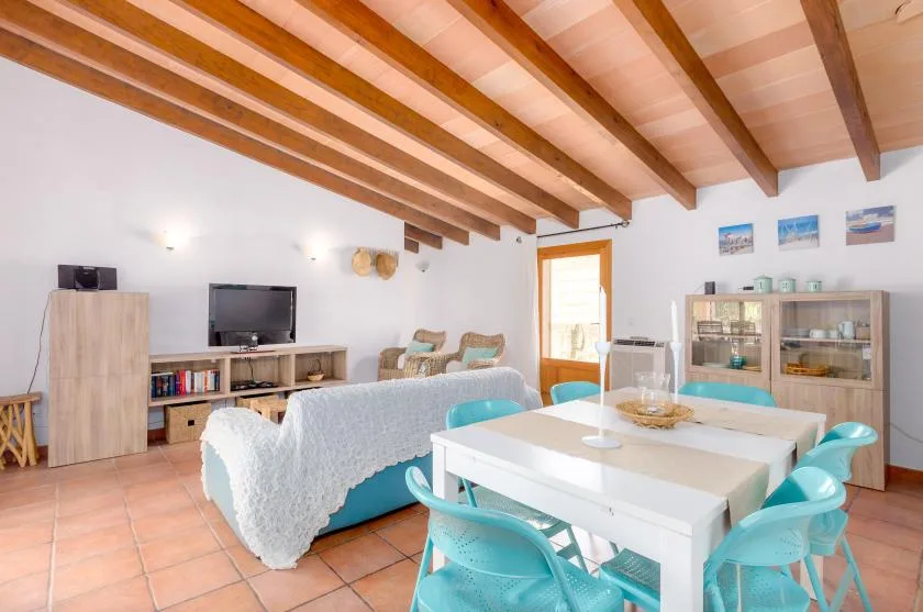A living and dining area with a white table and turquoise seating.