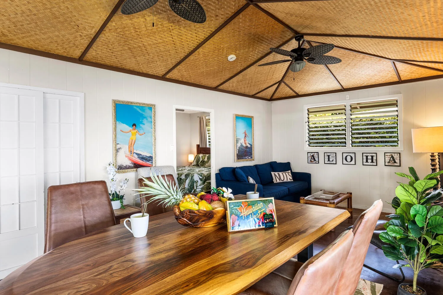 Una sala-comedor luminosa con mesa de madera, asientos y sofá azul.
