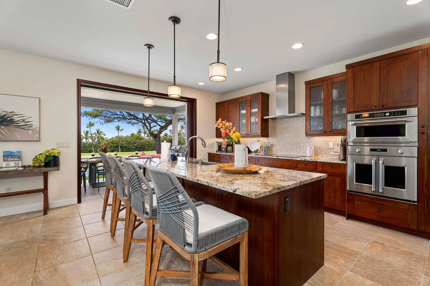 A spacious kitchen with a central island, bar seating, and wooden cabinets.
