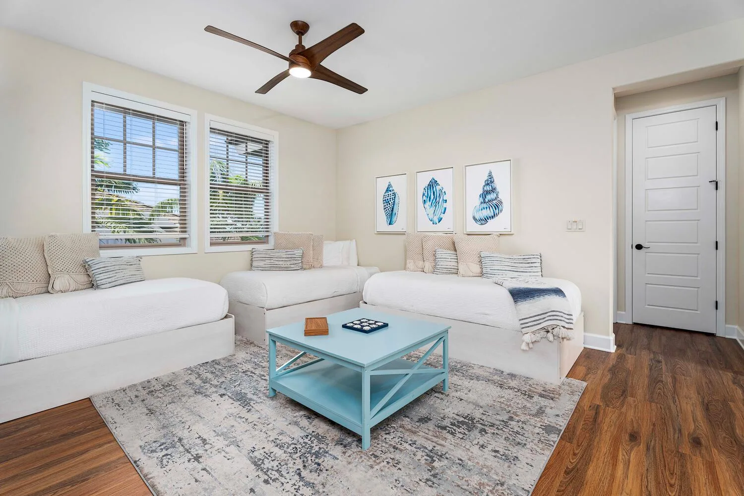 A bright living room with seating around a pale blue coffee table.