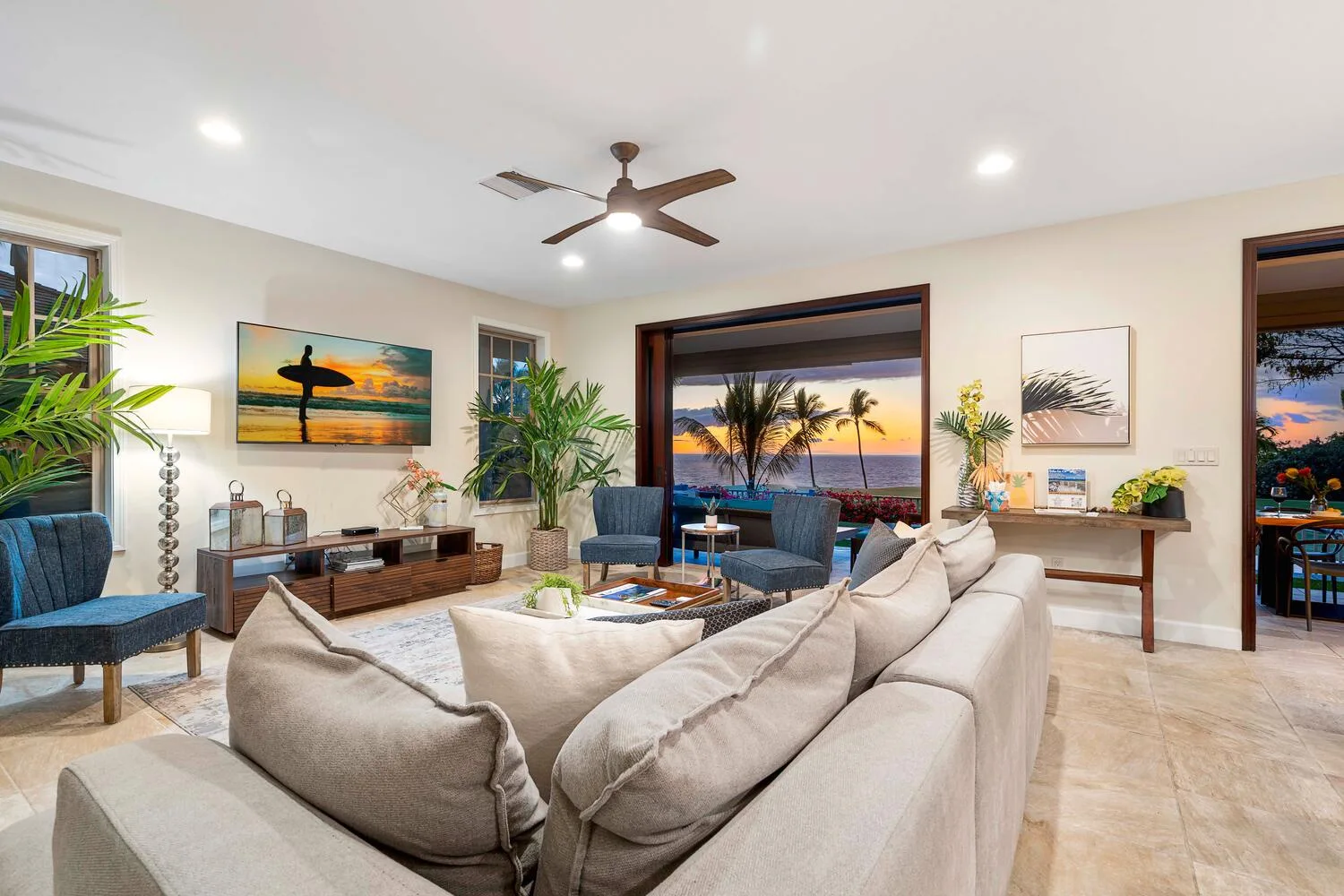 A bright living room with seating arranged around a coffee table and large windows.
