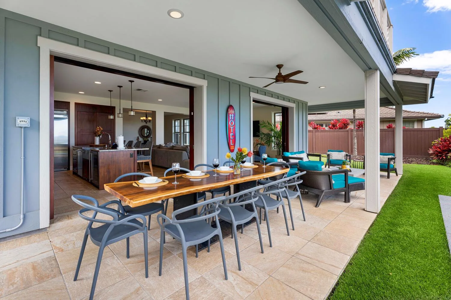 A covered outdoor dining and lounge area with a long table and seating.