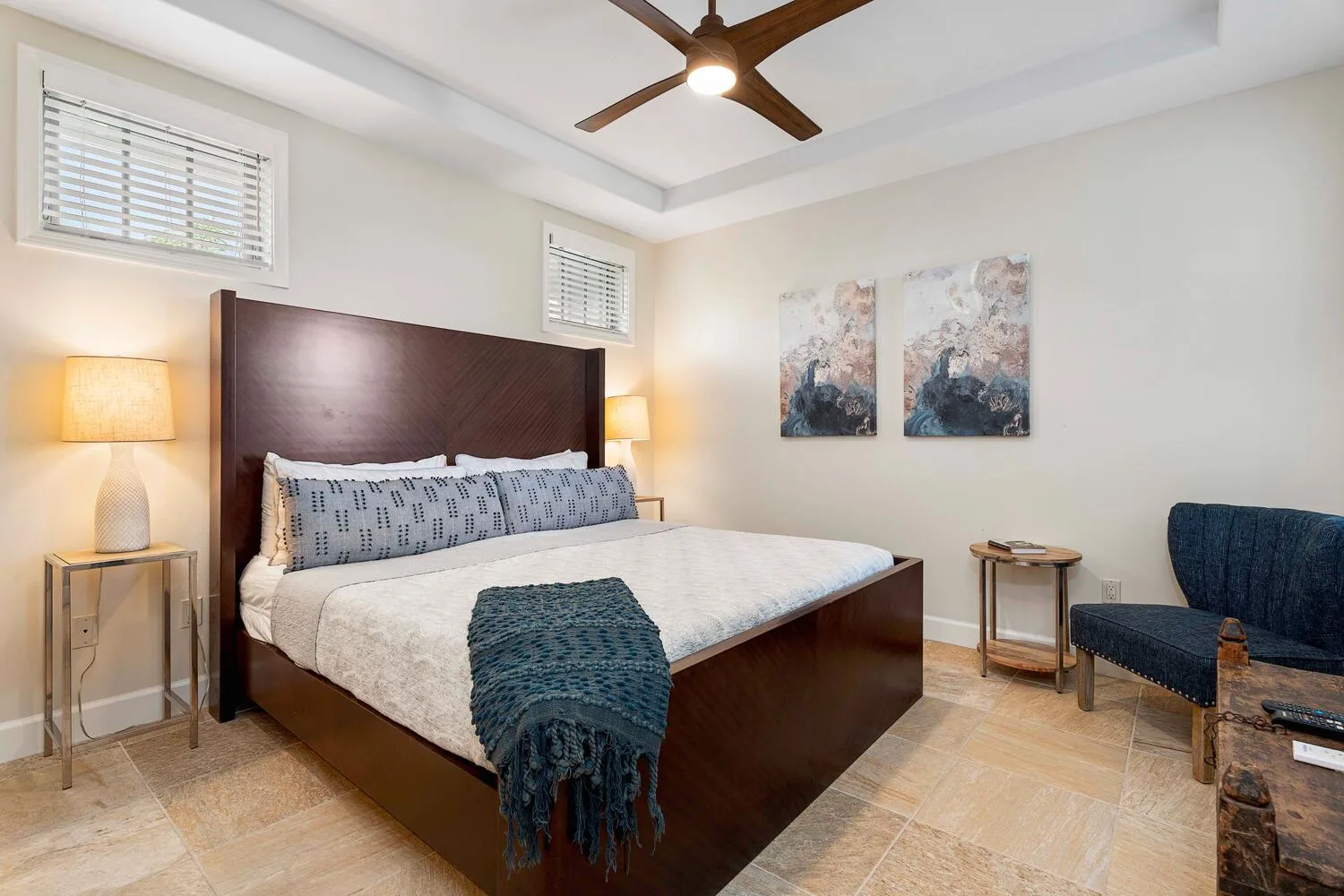 A bedroom with a large bed, bedside tables, and a ceiling fan.
