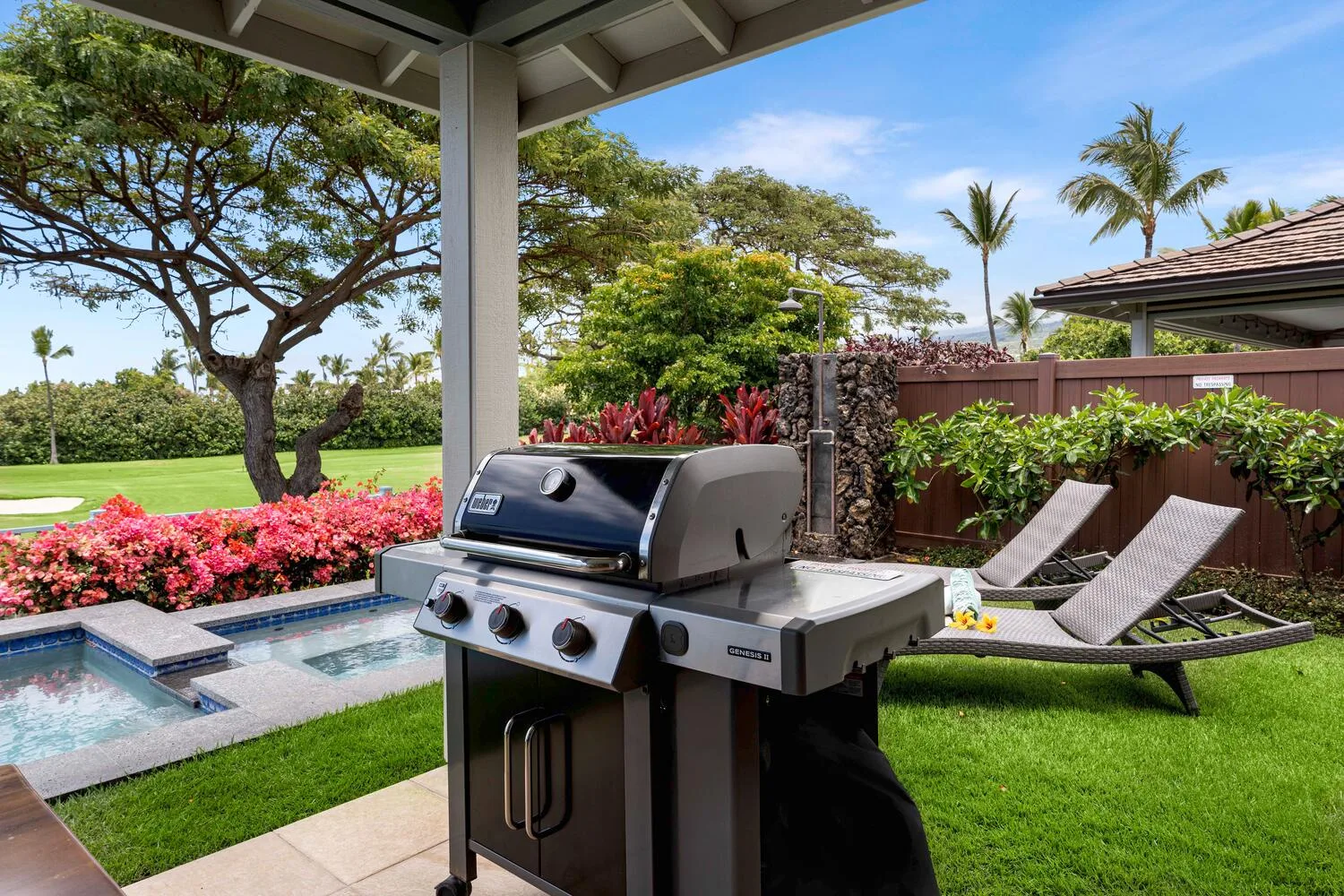 A covered patio with a grill, lounge chairs, and a small pool beside the garden.