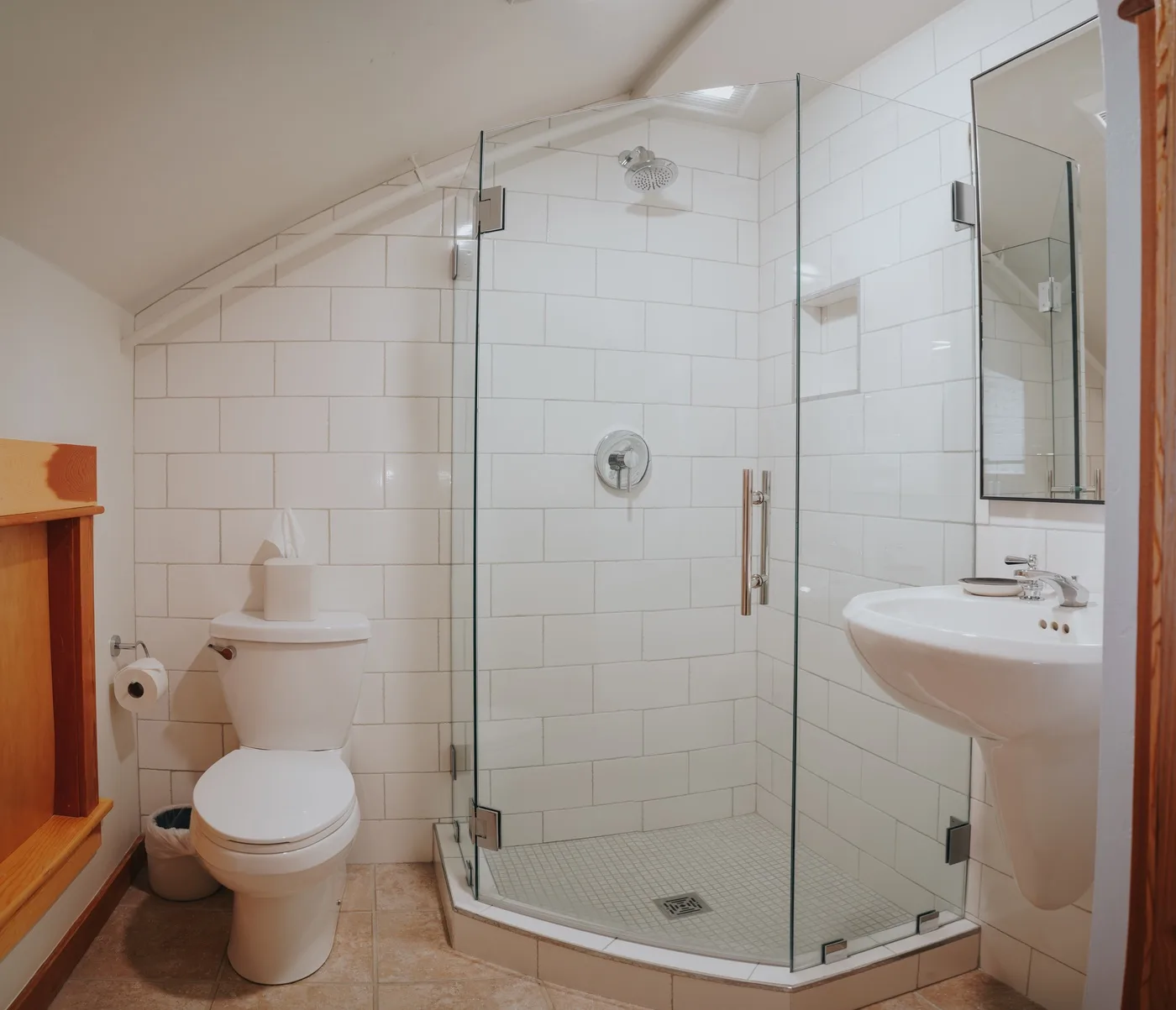 Un baño con ducha de vidrio, inodoro y lavabo.