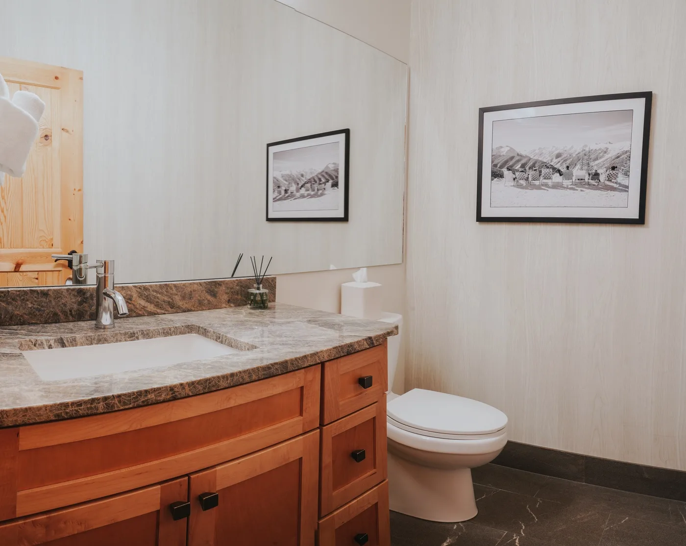 Un lavabo de baño con fregadero sobre la encimera y cuadros enmarcados.