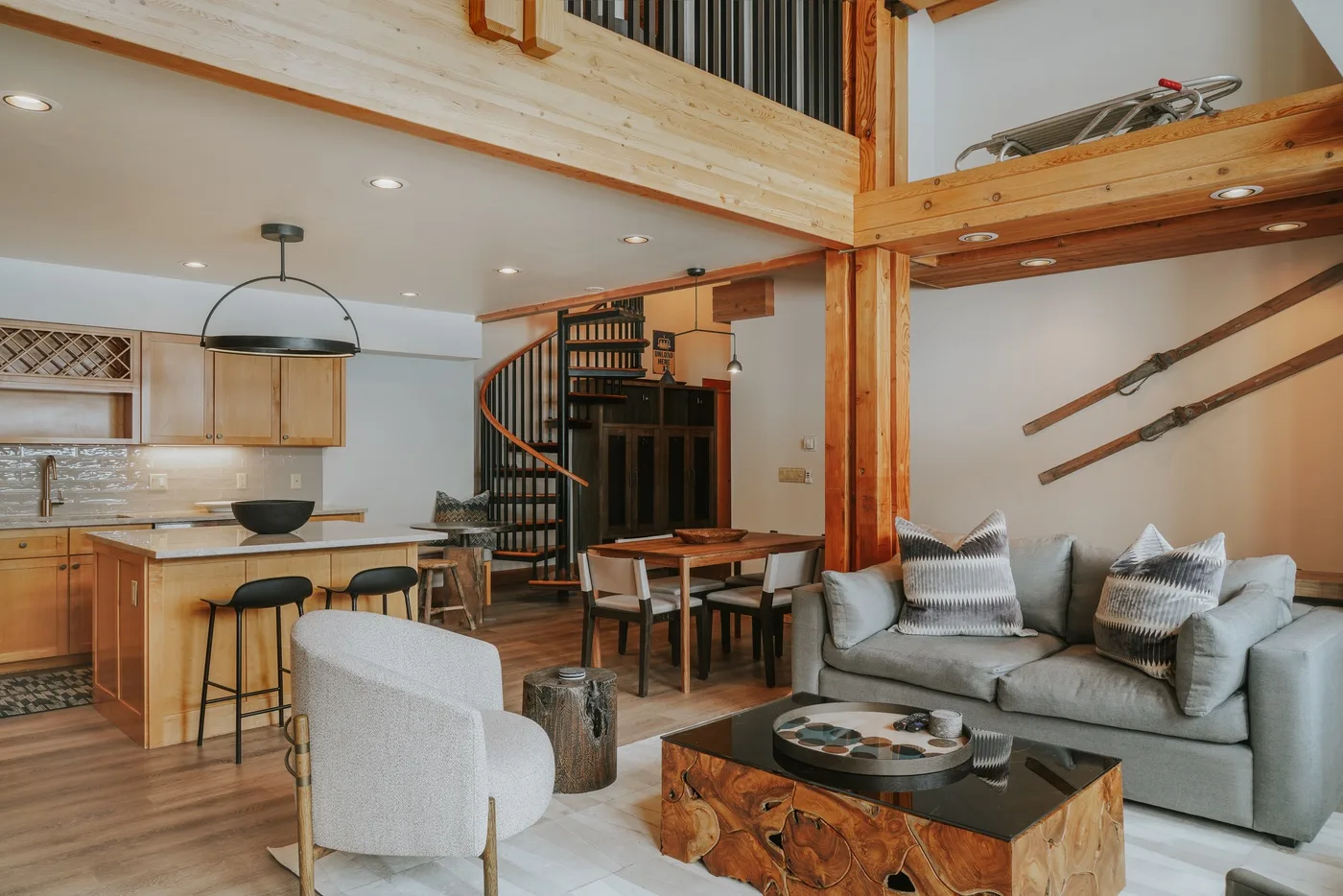An open-plan living and dining area includes a kitchen and a gray seating area.