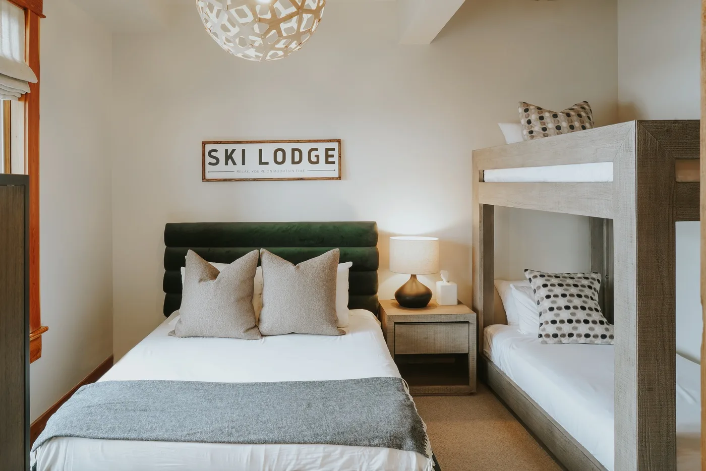 Un dormitorio con una cama doble, una litera y una lámpara de noche.