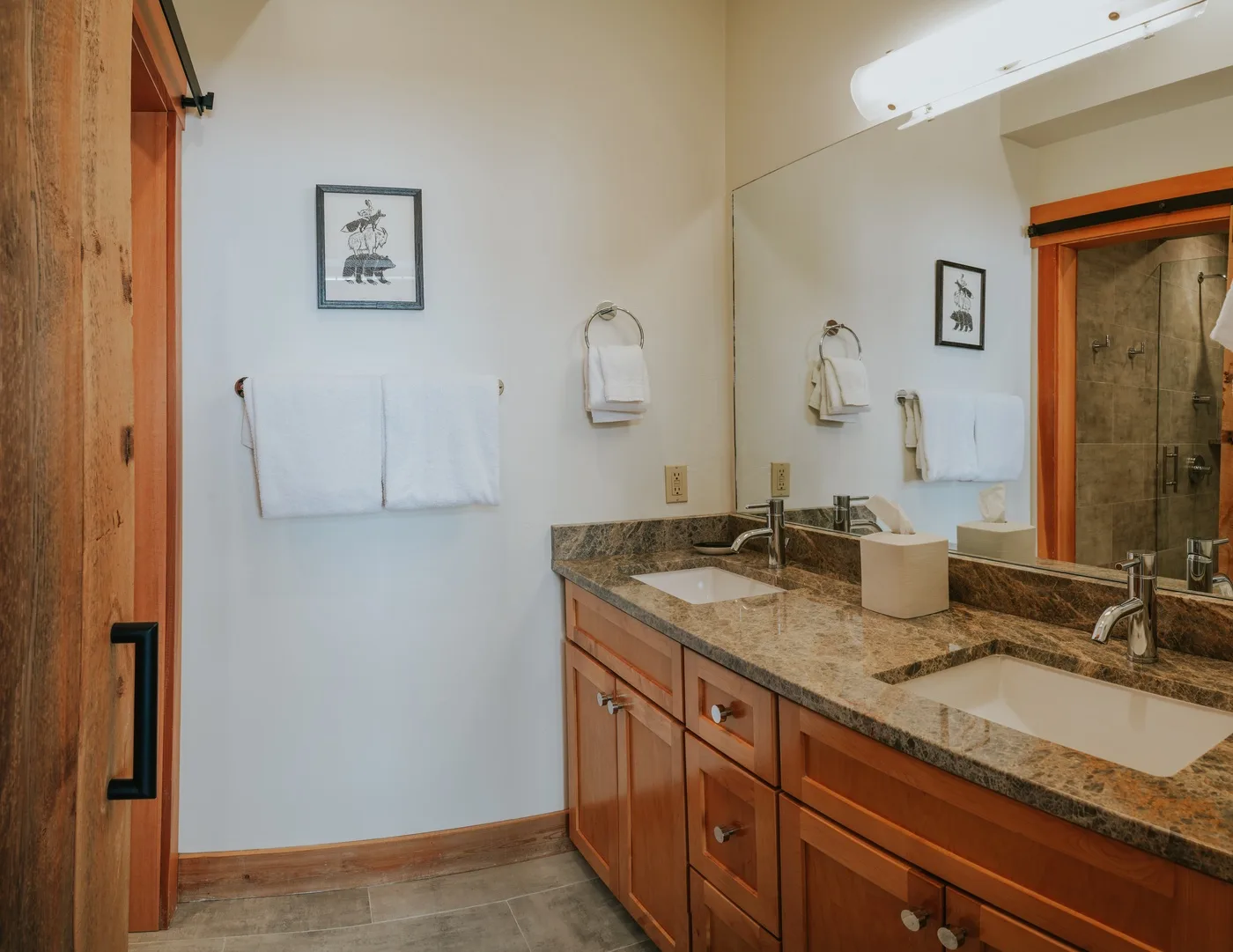 Un tocador de baño con lavabo, espejo y toallero.
