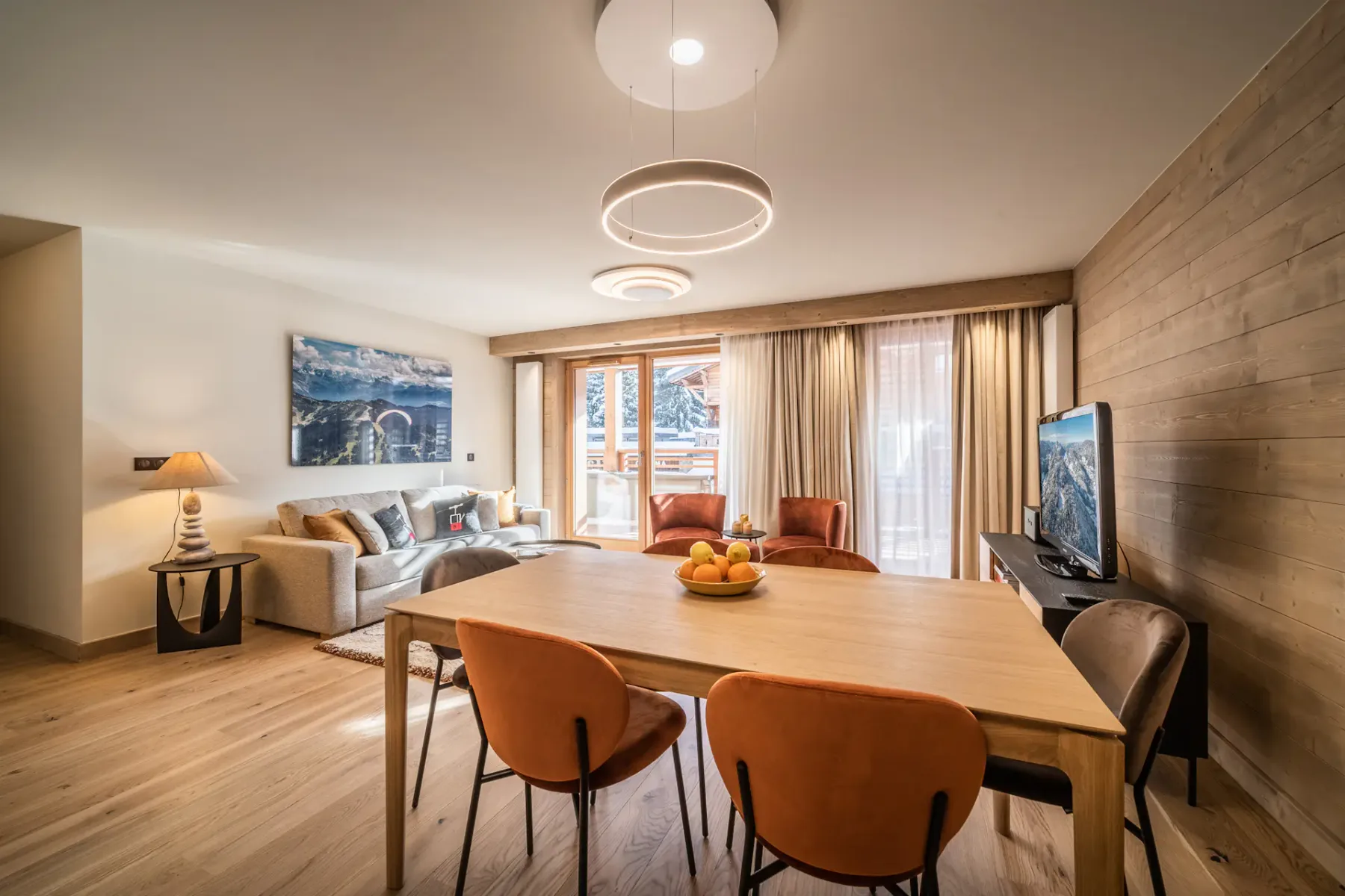 An open-plan living and dining room with a wooden table and seating.