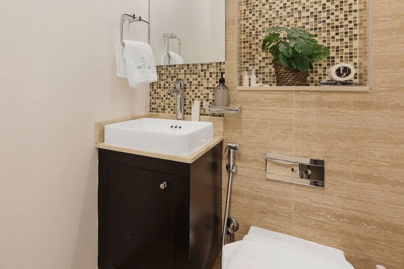 Un baño con lavabo, inodoro y paredes de azulejos.