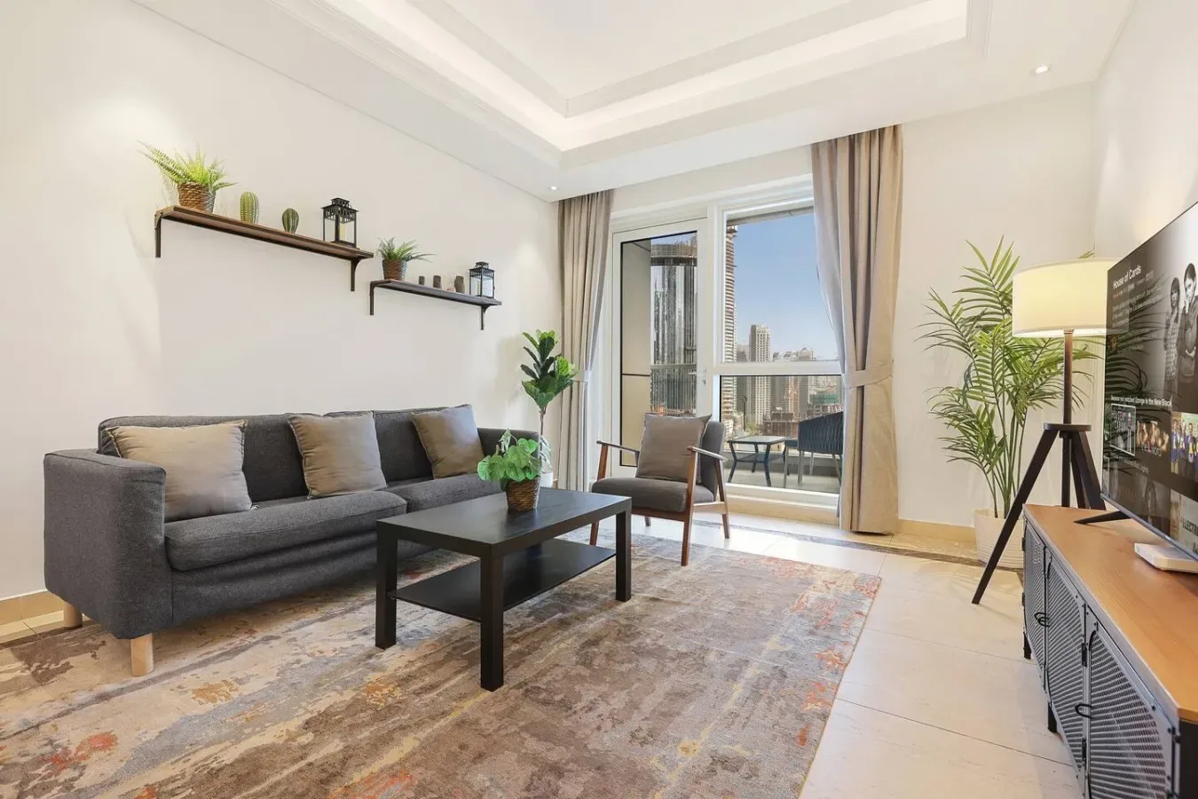 Una sala de estar luminosa con asientos, una mesa de centro y ventanas que dan a un balcón.