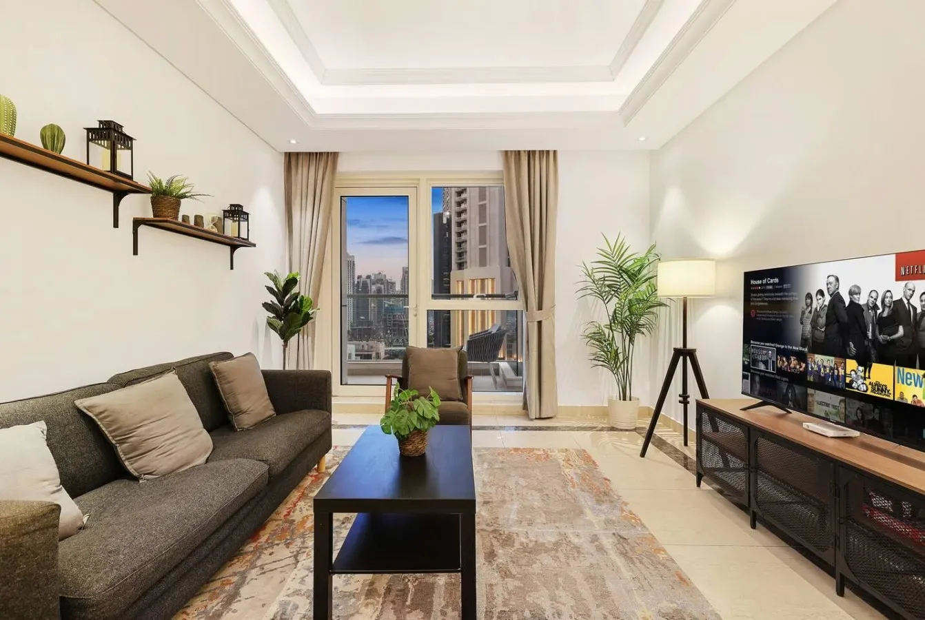 Una sala luminosa con asientos, una mesa de centro y un televisor.