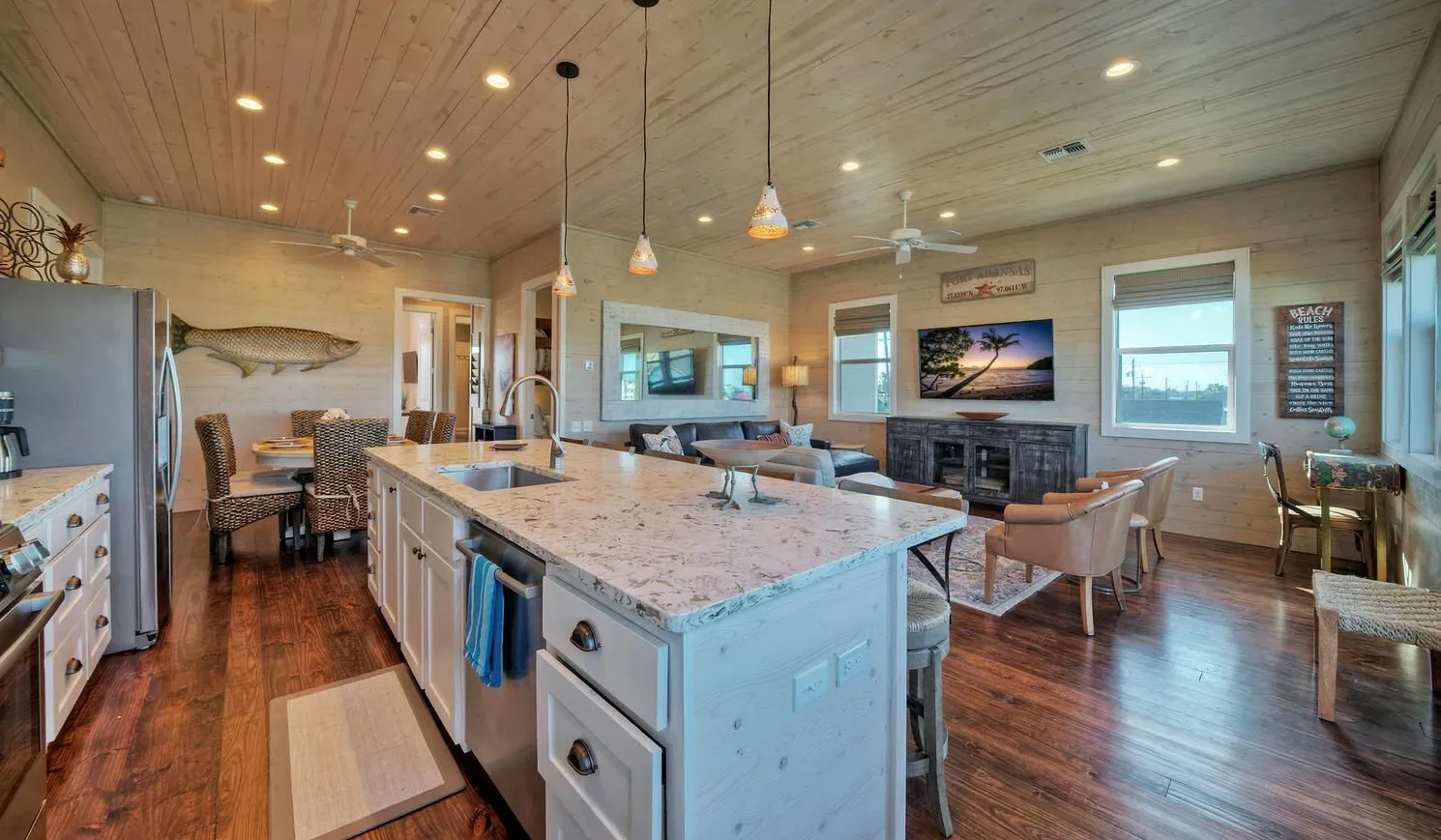 An open kitchen and dining area with a large island and a living space beyond.