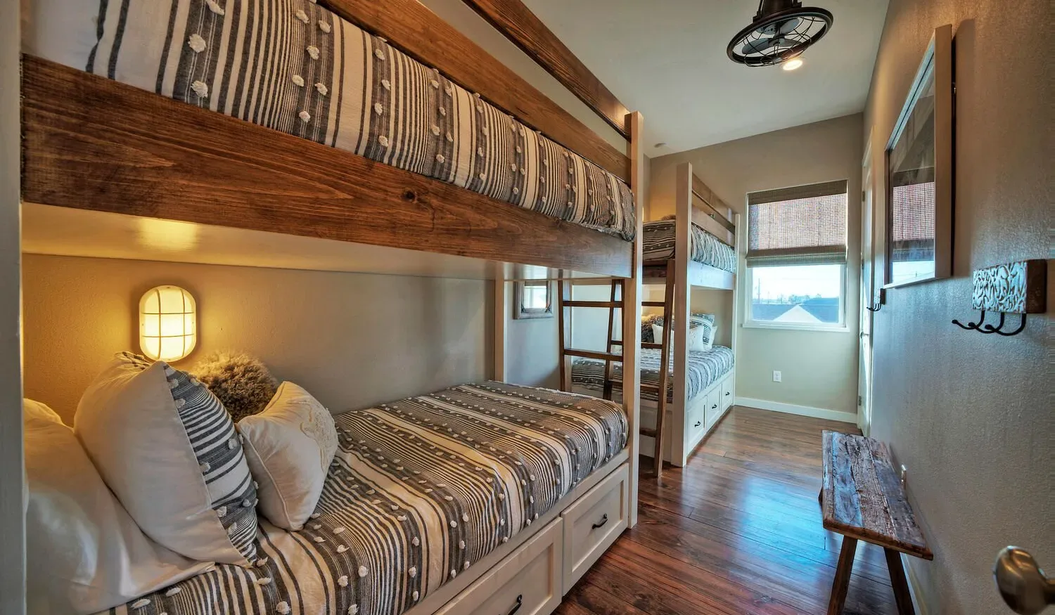 A bedroom with a wooden bunk bed and a window.