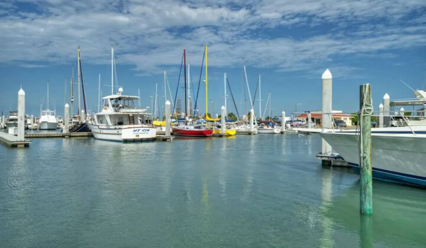 A marina with sailboats and motorboats moored along the docks.