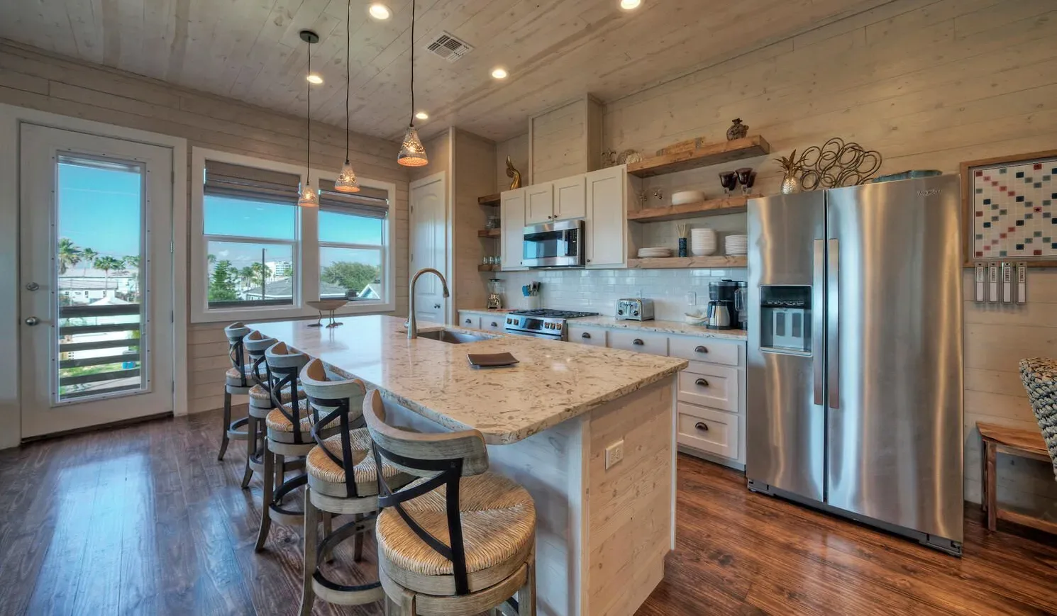 A spacious kitchen with a central island, bar seating, and stainless steel appliances.
