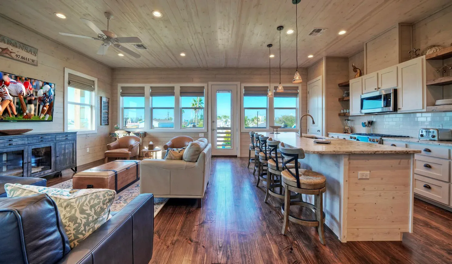 An open living room and kitchen with seating around a large island.
