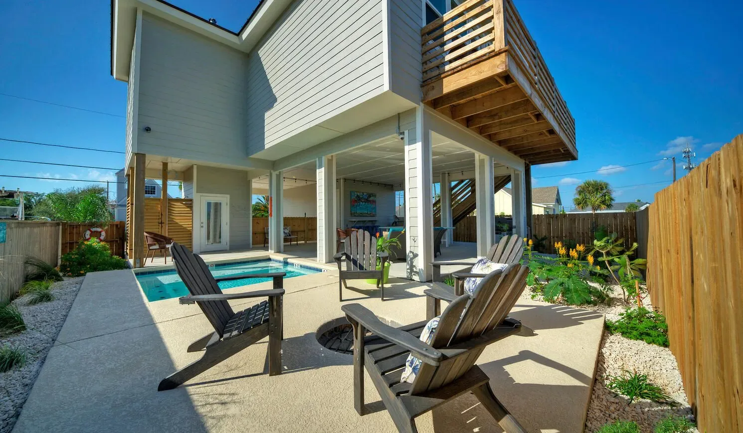 Outdoor patio with lounge seating beside a swimming pool.