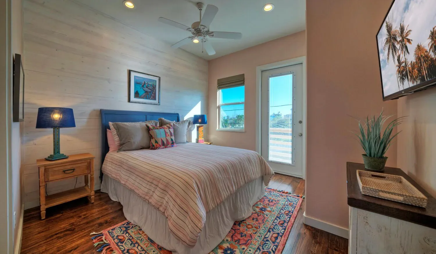 A bedroom with a bed, bedside tables, and a glass door opening onto a balcony.
