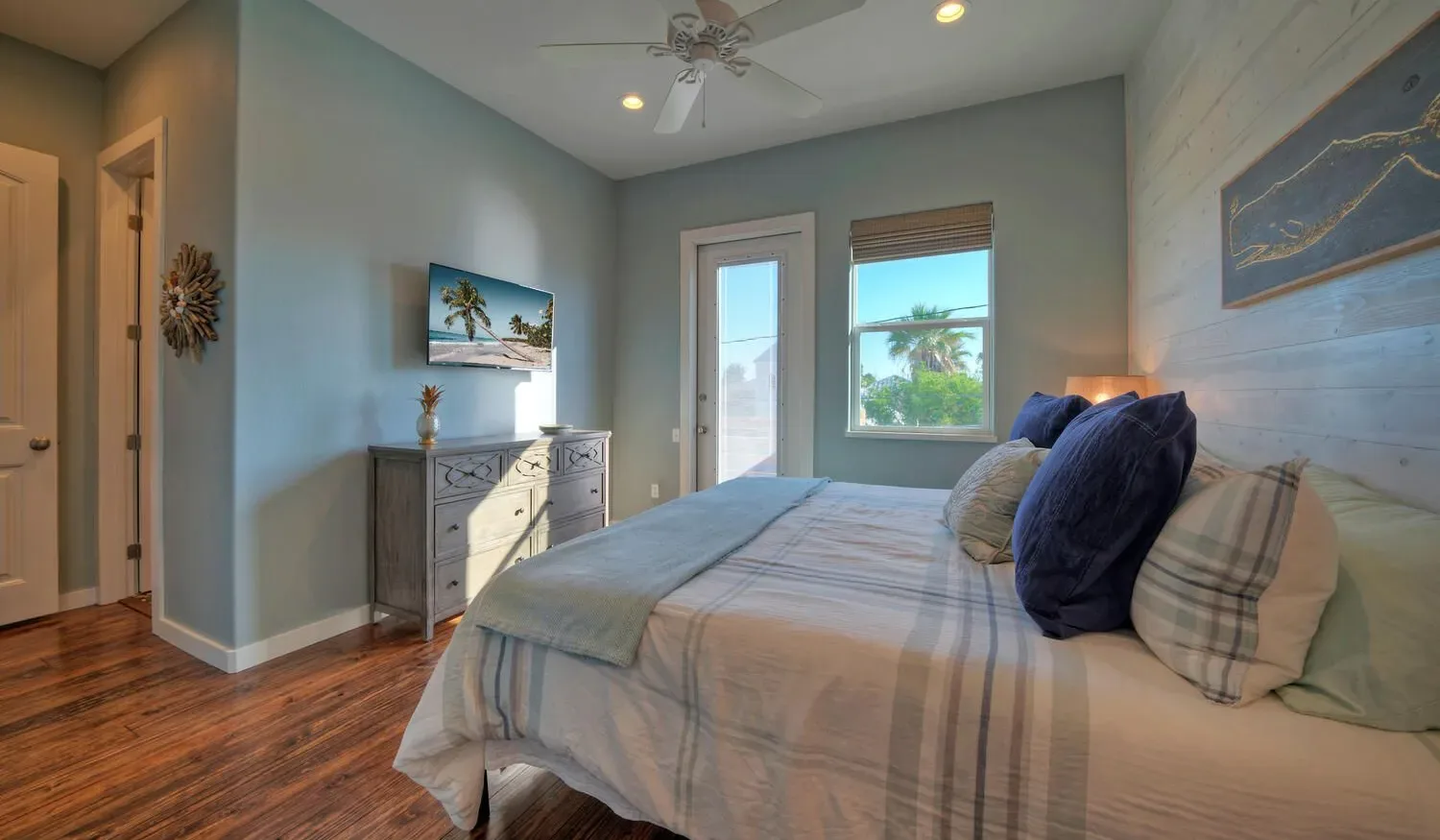 A bedroom with a neatly made bed and a dresser against the wall.