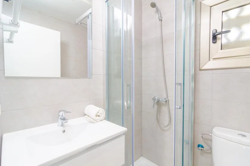 Un baño con lavabo, espejo y ducha de vidrio.