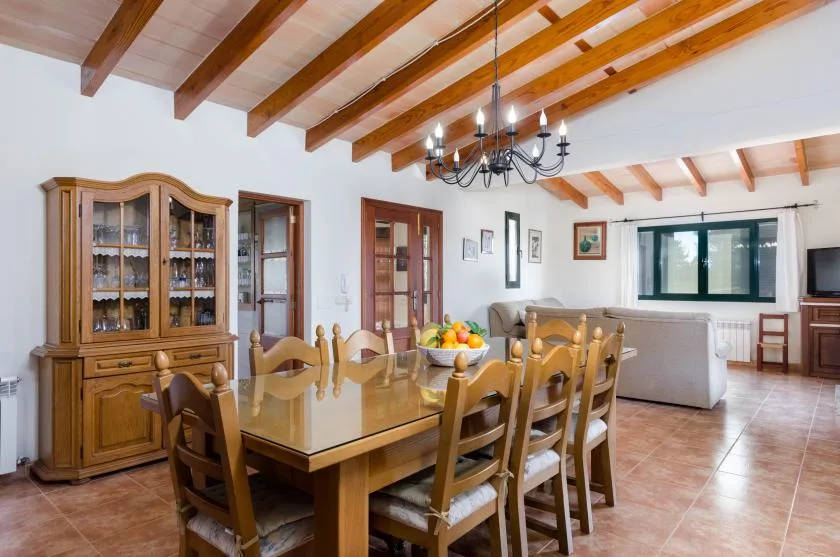 Un comedor con una mesa de madera y un aparador con puertas de cristal.