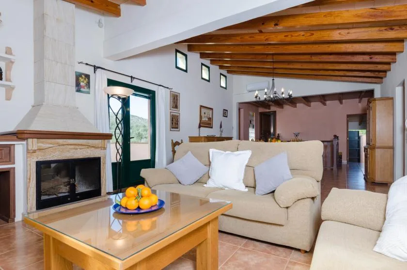 Una sala de estar con chimenea, sofás y una mesa de centro de madera.