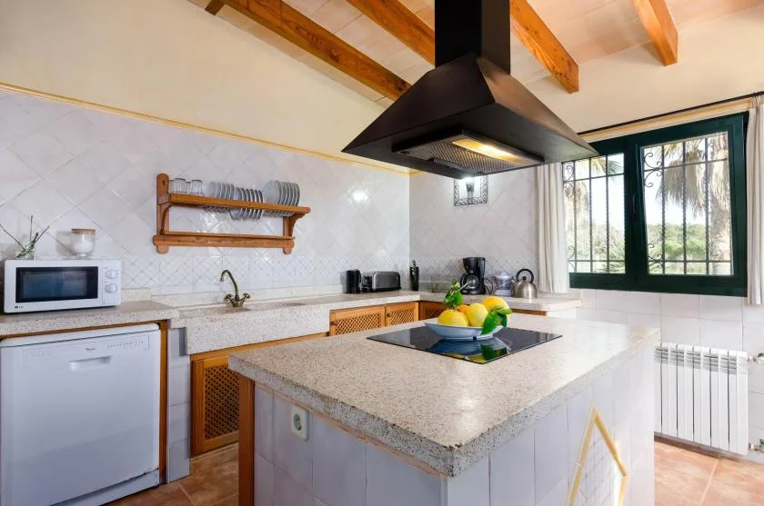 Una cocina luminosa con una isla central y ventanas grandes.