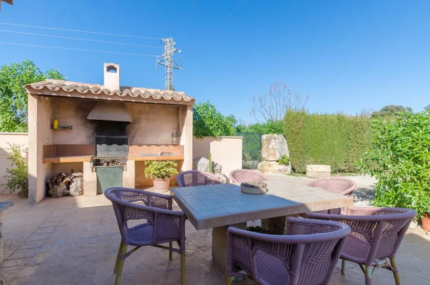 Una zona de comedor al aire libre con una mesa y una barbacoa de obra.
