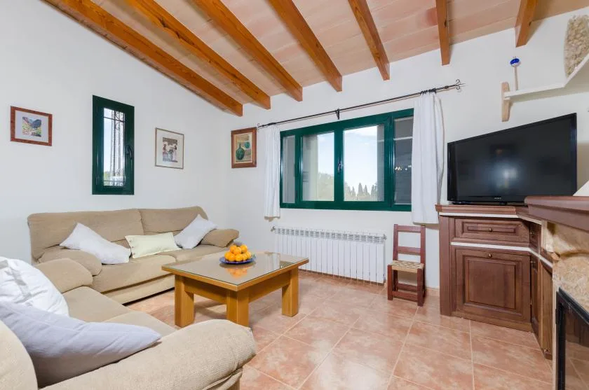 Una sala de estar con asientos, una mesa de centro y un televisor.