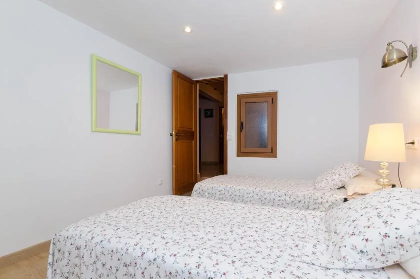 Un dormitorio con ropa de cama estampada y una puerta de madera abierta.