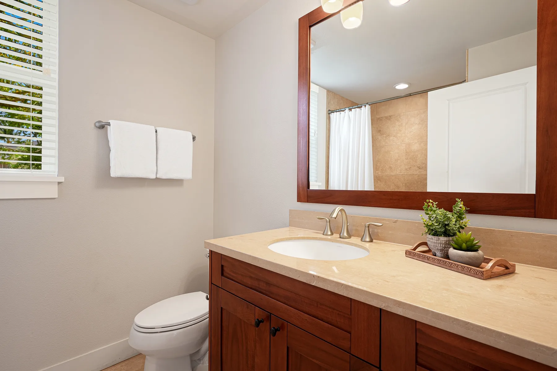 Un tocador de baño con lavabo y un espejo grande.