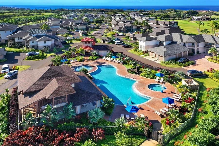 Vista aérea de un vecindario residencial con una piscina y casas alrededor.