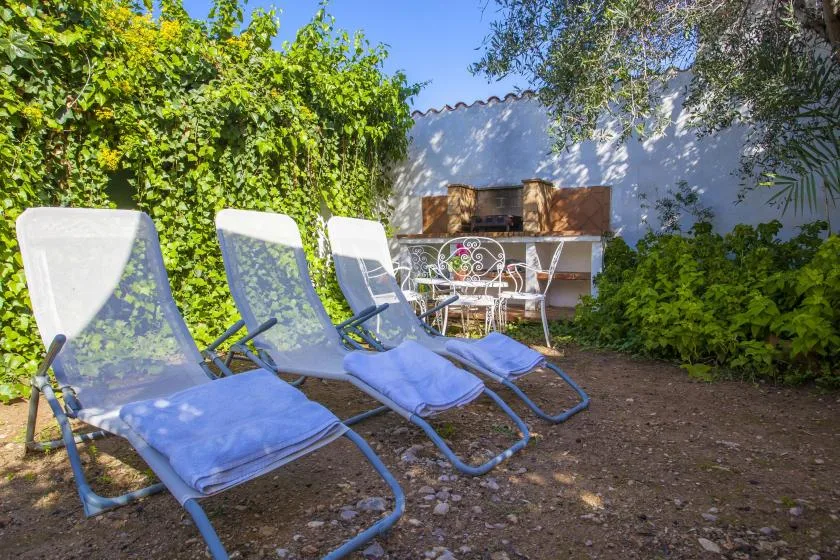 A garden patio with reclining loungers and a small outdoor dining table.